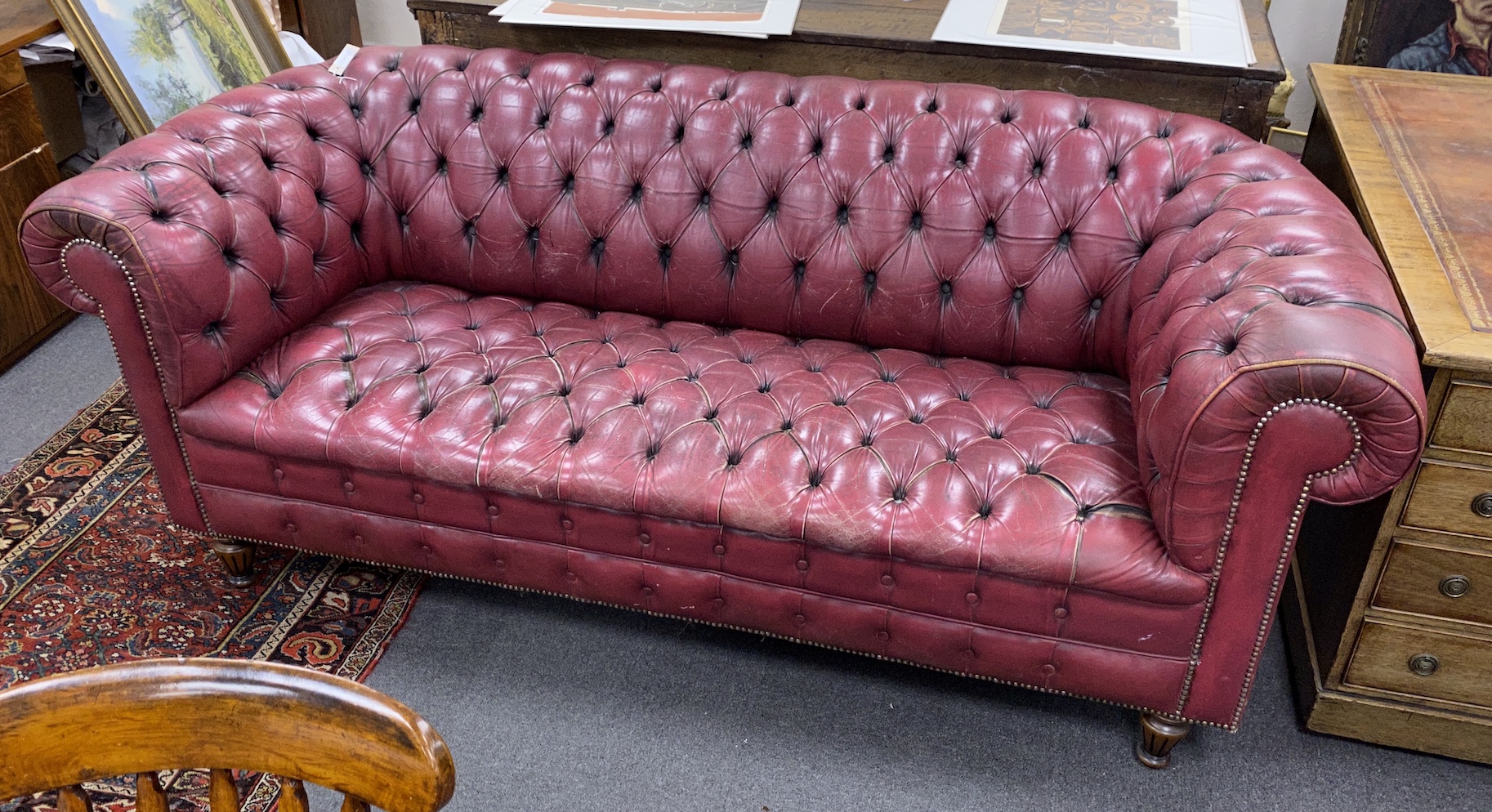 A Victorian style buttoned burgundy leather Chesterfield settee, length 210cm, depth 90cm, height 82cm